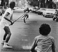 Boys playing stickball in street