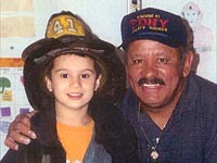 Sammy Marquez with grandson proudly wearing his firefighter gear